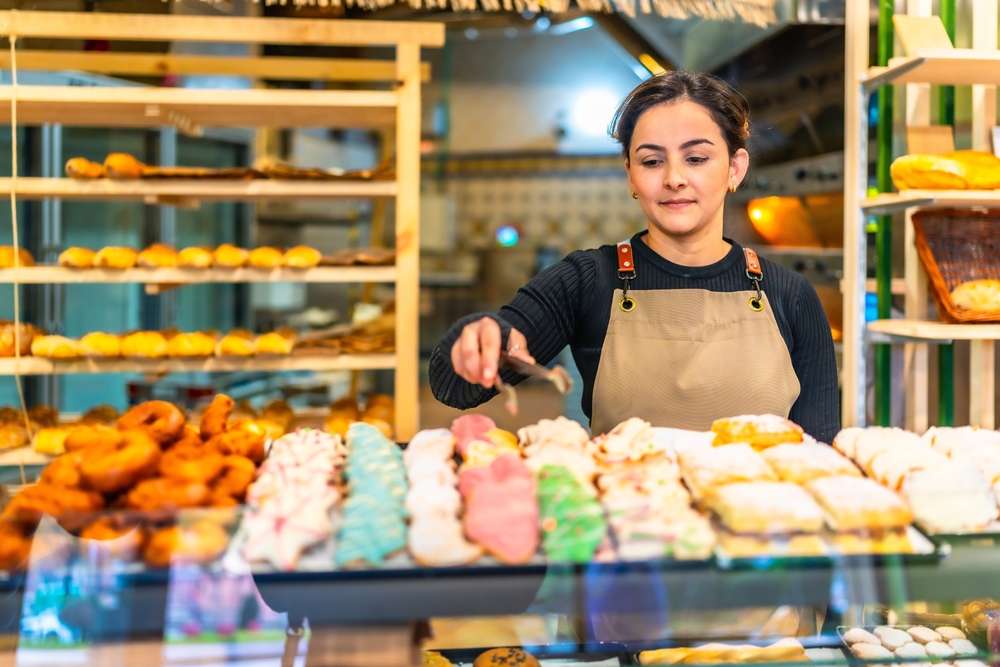 Latin,Young,Woman,Wearing,Apron,Selling,Artisan,Pastries,In,A